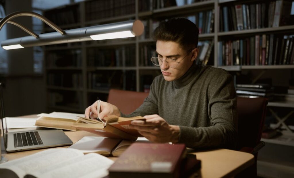 Image of a man researching in a library.