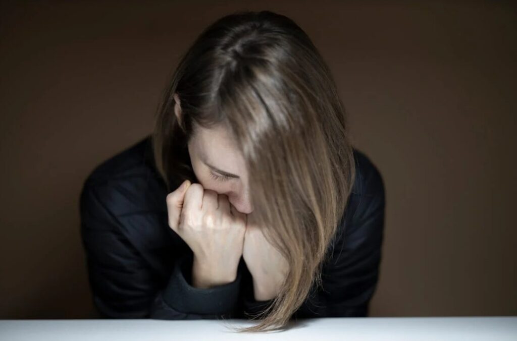 Woman cringing in fear. 