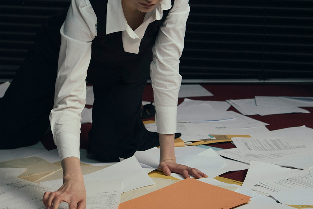 Someone sifting through papers to visualize how detailed a writer might want to go into their character profiles