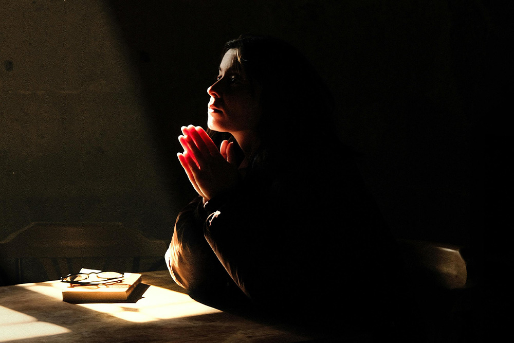 Character dealing with dilemma and praying to suggest a visual segue between inner conflict and dilemma