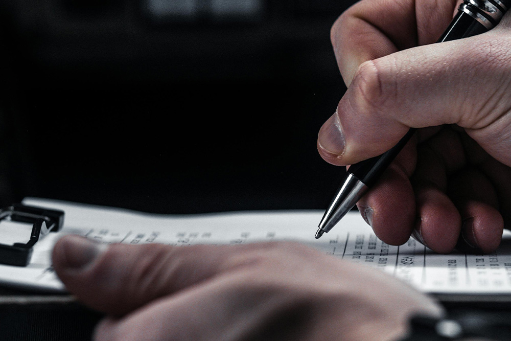 Closely marking up a page on a clipboard