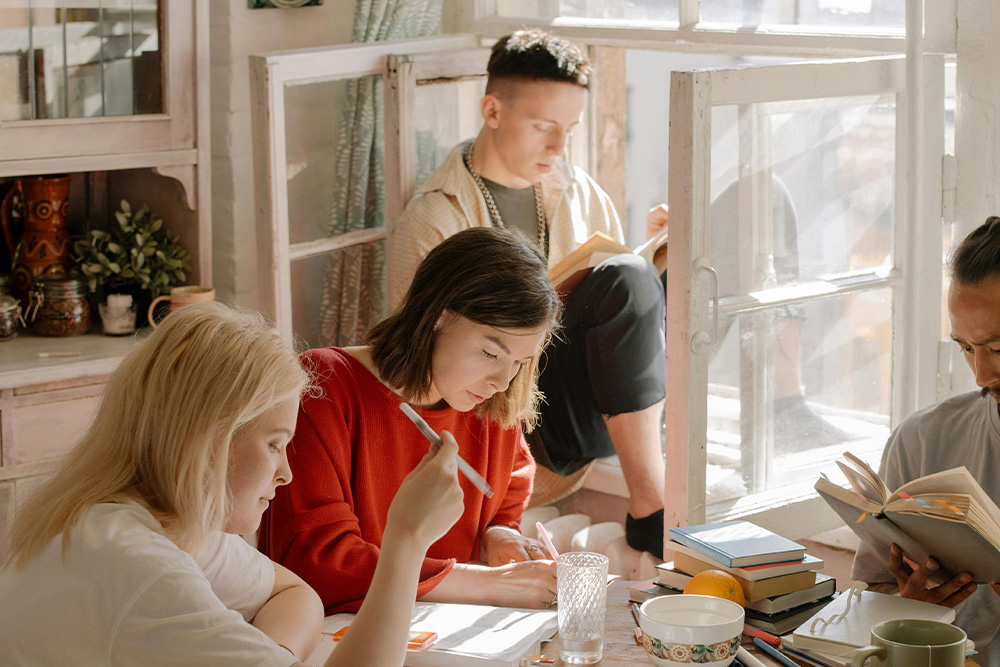 character from featured image editing work with the company of trusted peers and friends, marking up a sheet of paper