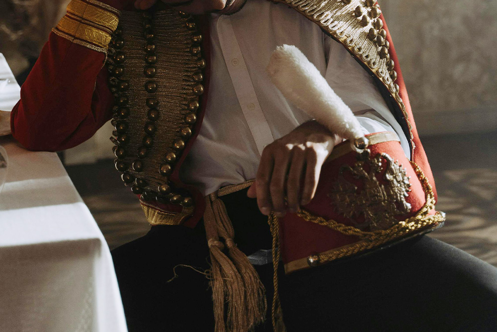 A royal character with his jacket undone and his hat hanging down in a sort of defeat