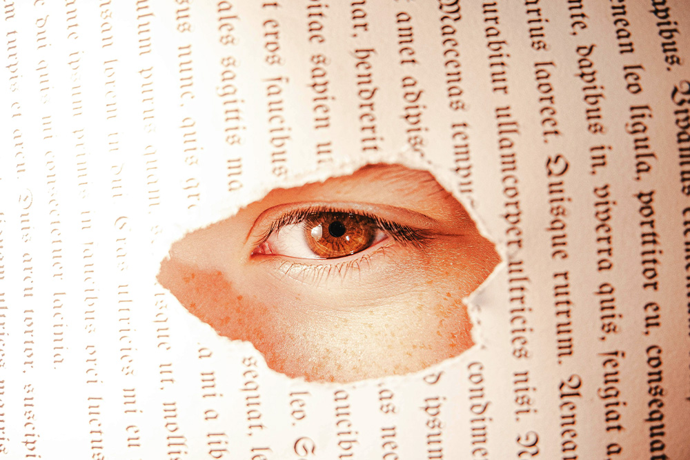 A page of a book with a hole in it, a visual metaphor for plot holes to suggest an audience looks through one's work to the author when a plot hole is left in