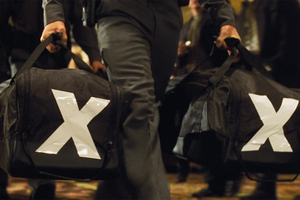 Screen grab of duffel bags mentioned in the passage from the movie Ocean's Eleven as a visual cue to reference the passage in the film the text refers to.
