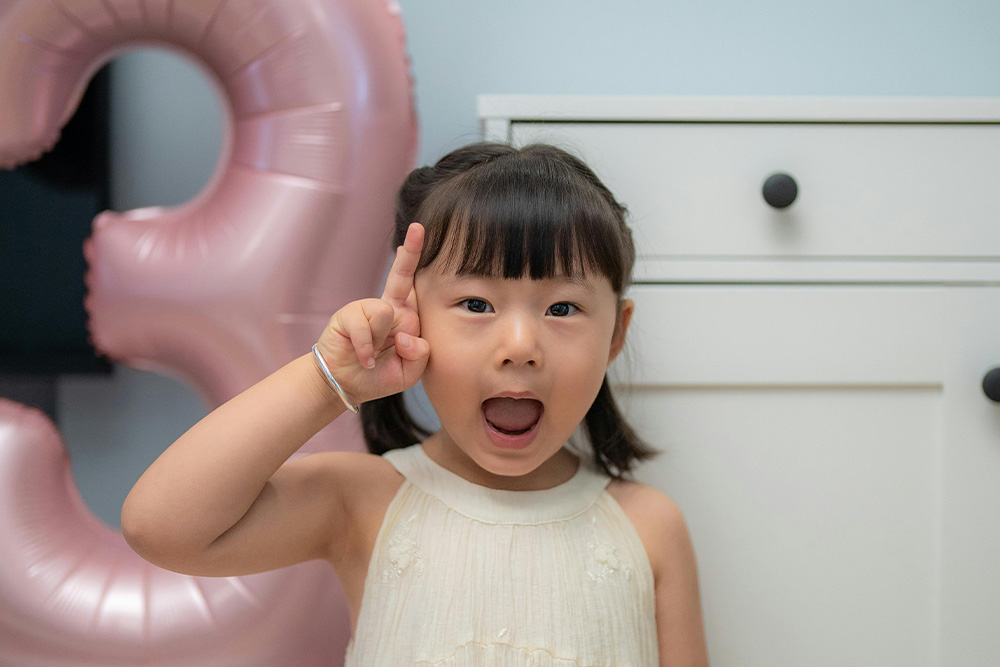 A little girl flipping off a big "three" shaped balloon to suggest to writers that the rules are meant to be broken but to give a fun vibe to the whole ordeal