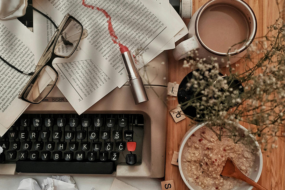 Tips for writing a novel depicted by the messiness of a workspace — food, coffee, and a place to keep all of those things.