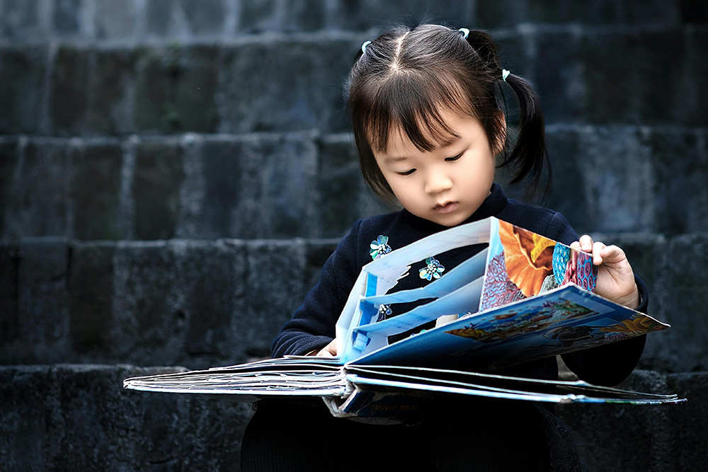 A young reader with a pop-out book to symbolize the effect of letting the reader fill in the details in 6-word memoir