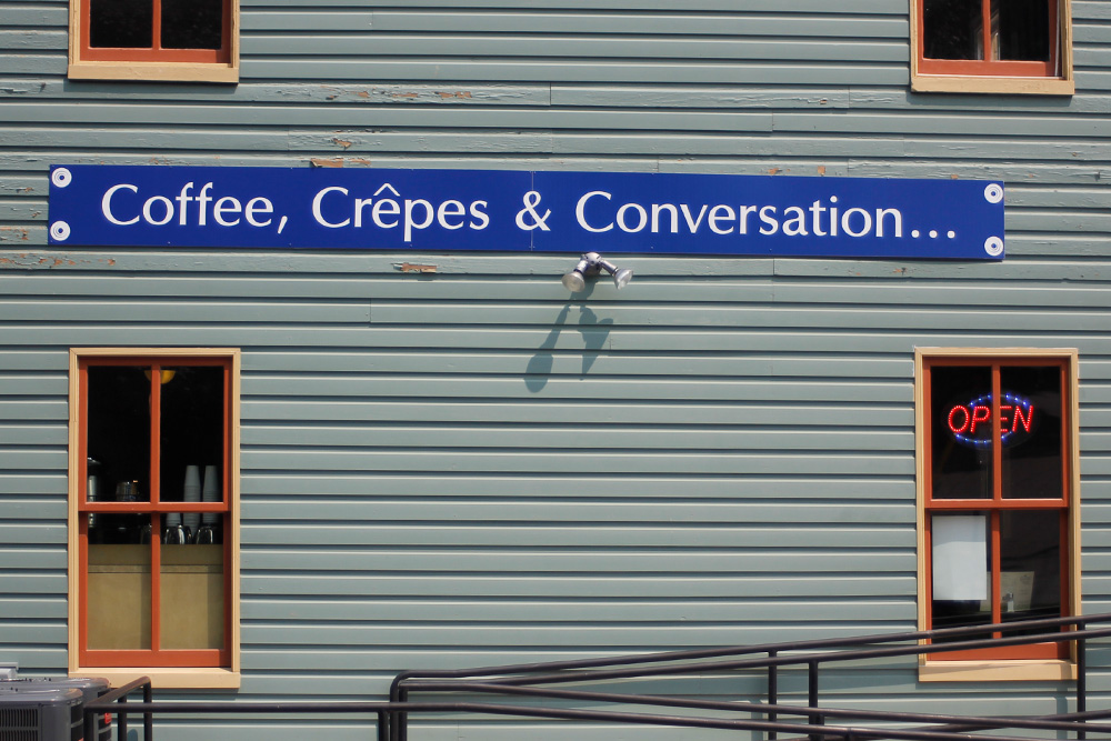Pictured: a café that has a sign out front that employs alliteration and immediately evokes a strong feeling that answers any reader who asks the question: "What is alliteration?"