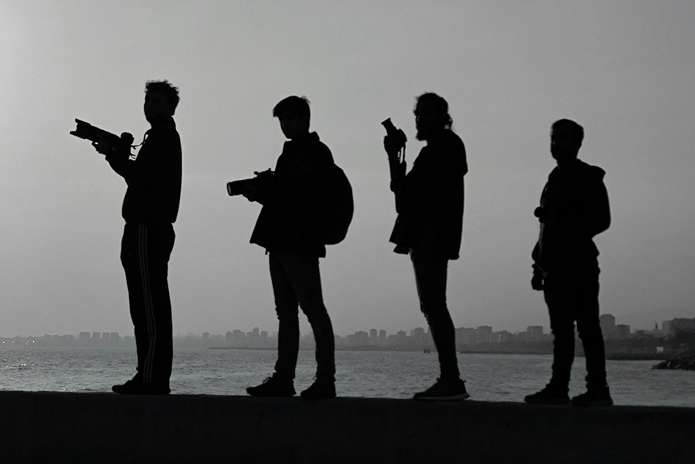 Photographers and their shadows are set against a cloudy skyline as a dramatization of how to outline a screenplay