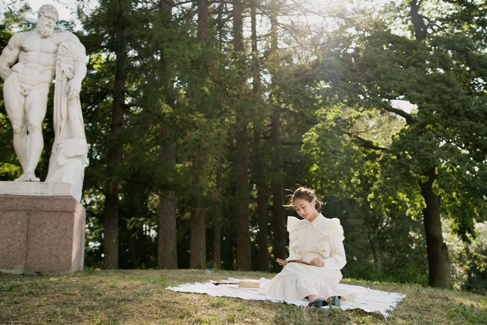 A woman sits alone on a picnic blanket to think austerely and ask questions to discover her story