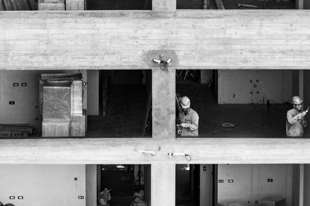 Two men paint the sides of a room in one story of a building to suggest the parts of a story as a physical relationship to one's own literature