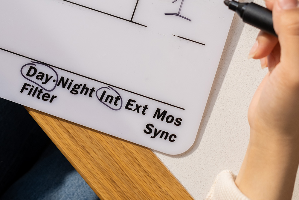 A slate adorned with different settings to suggest how the page translates to screen when asking what is a screenplay?