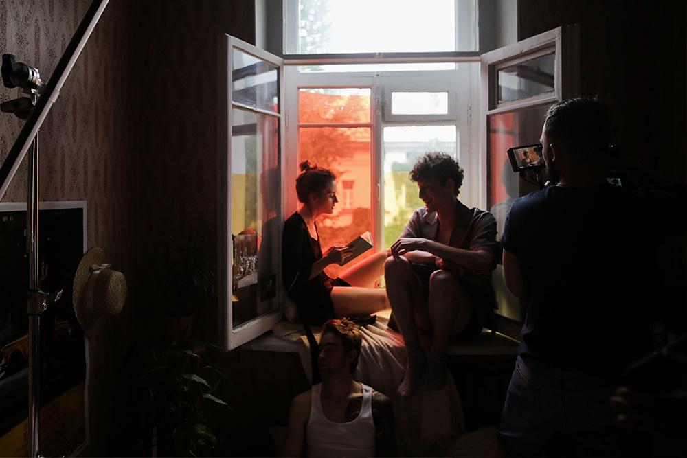 Scenic movie shooting, people sit in a window to depict advice on writing memoir in the form of writing a scene and not a movie