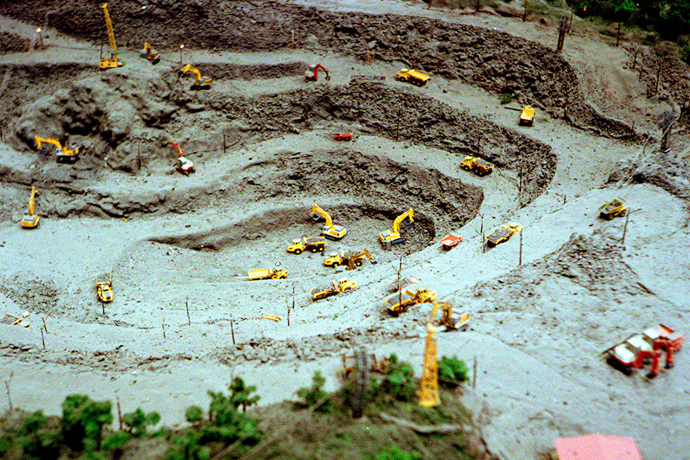 Toy excavators in colorful miniature to suggest the revision process as an emotional ordeal in advice on writing memoir