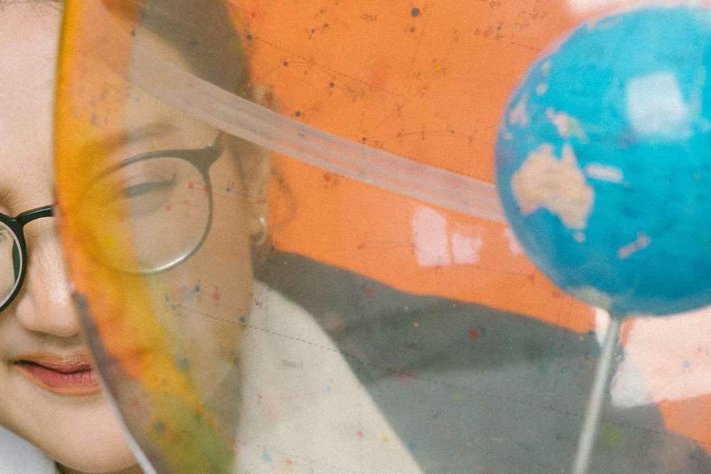 A woman looks into a concentric plastic globe to suggest misguided worldviews in character ideas