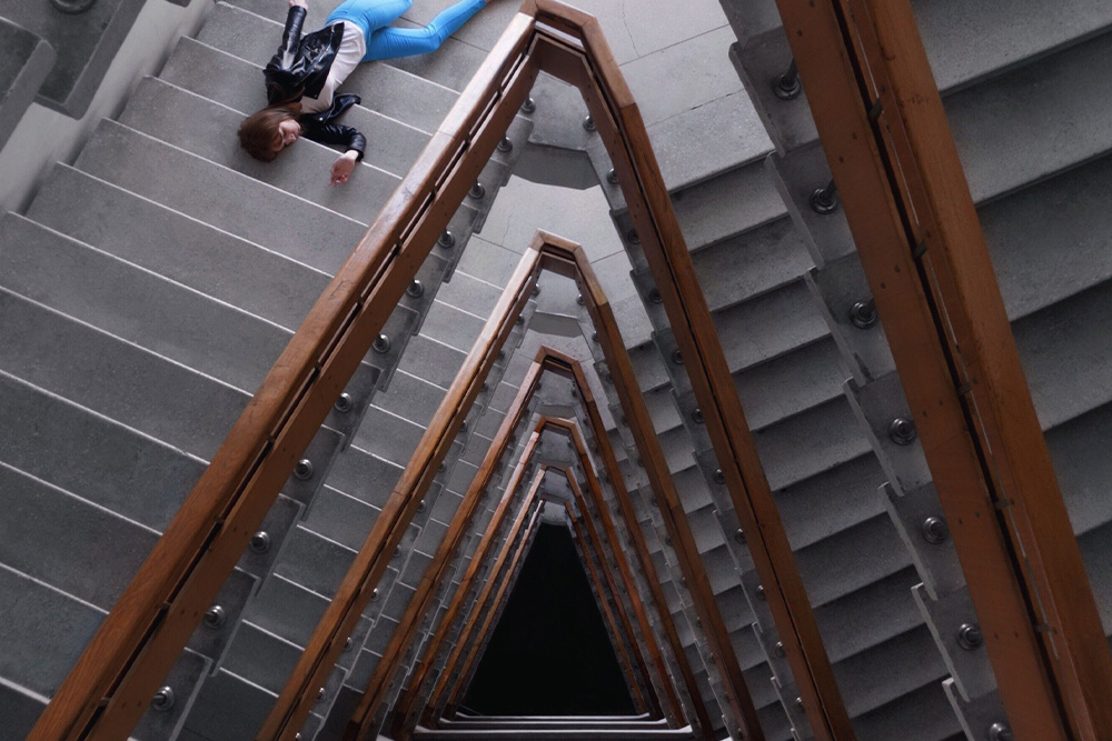 A woman laying on a paradox staircase suggests that a central contradiction is established in character ideas