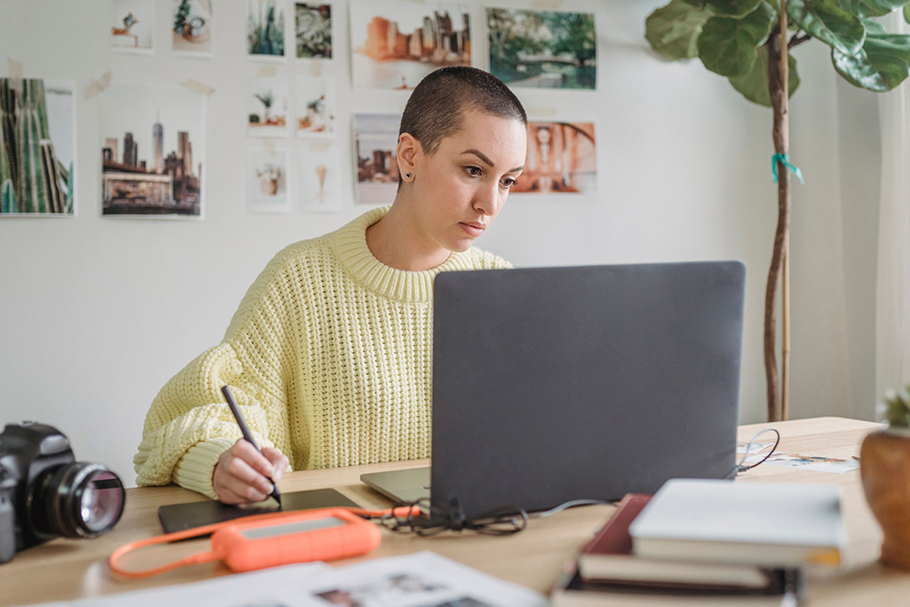 A woman works tirelessly at a desk to suggest that the creator archetype is shown and not told to the audience