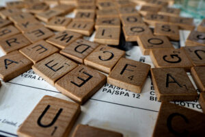 A series of scrabble tiles placed on a plain white sheet of paper to suggest the fun of choosing effective descriptive adjectives