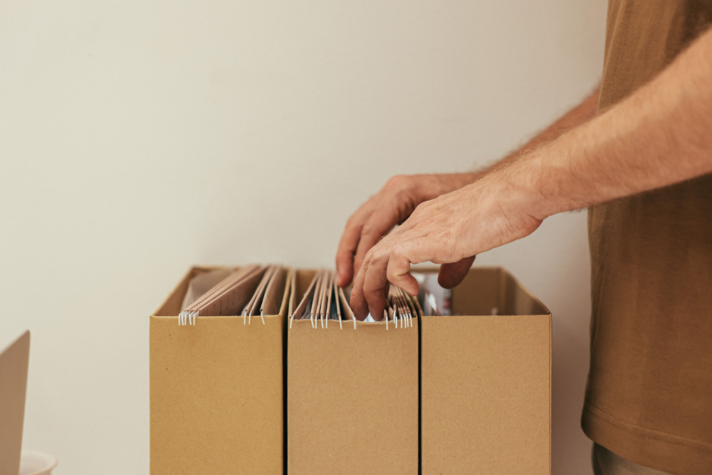 A person files through some boxes to learn how to copyright a book and convey it in a warm happy light