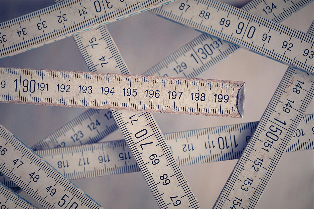 A bunch of rulers intersect one another in a triangular and rhomboid composition to suggest how long a query letter should be 