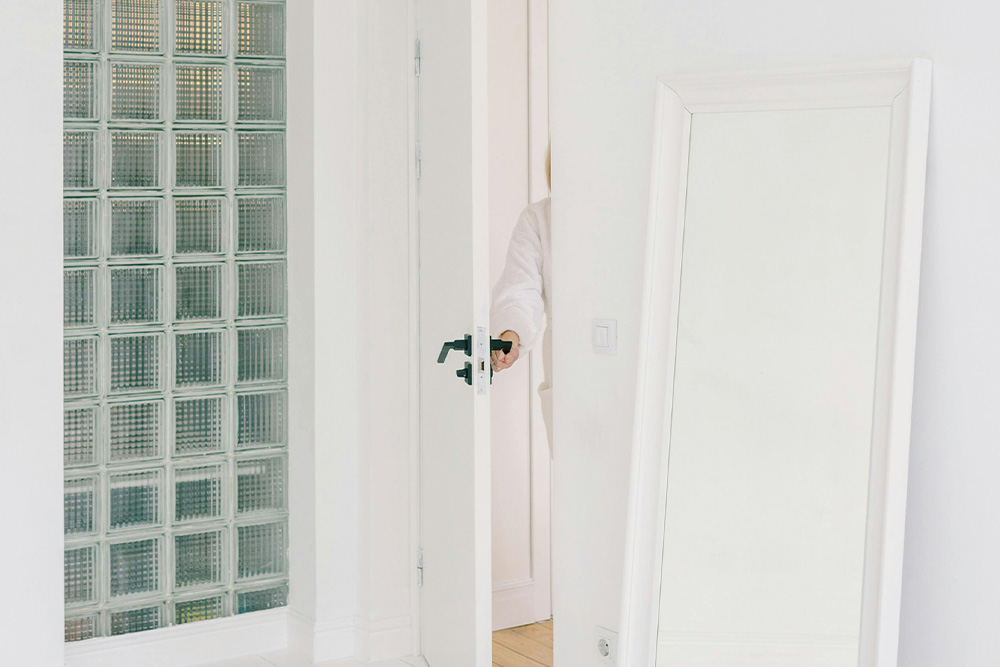 A person opening a door into a brightly lit room suggests a beauty to opening a query letter gently