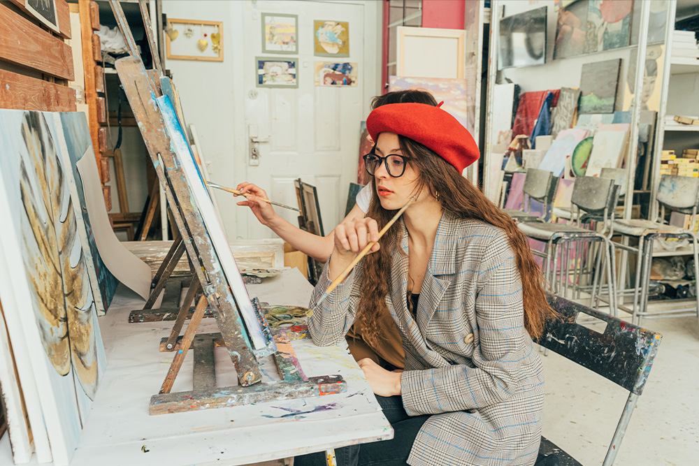A artist pauses to observe her painting as a representation of how to step away from the story when you've lost the plot