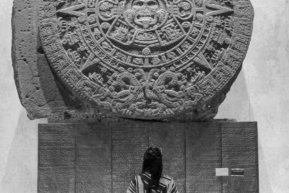 Someone looks at a Mayan language tablet to suggest that the language of the story is tackled by revising vs. editing