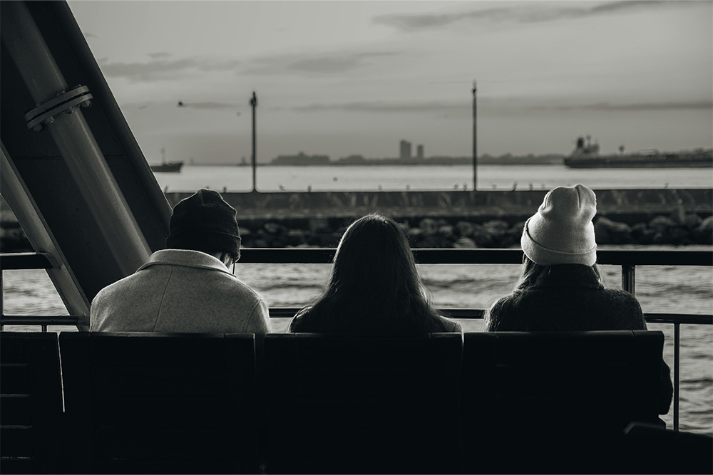 Three people sit at a bench to visualize the concept of comparing third person perspectives