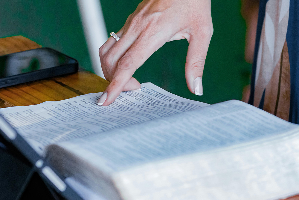 A hand points to a piece of paper to offer the reader's attention to examples in literature