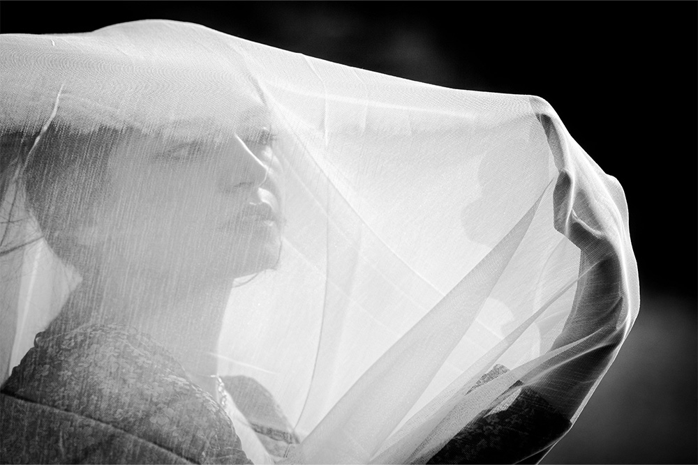 A woman behind a veil looking off into the distance is suggesting something sideways in the subtext of the image and the writing of the blog