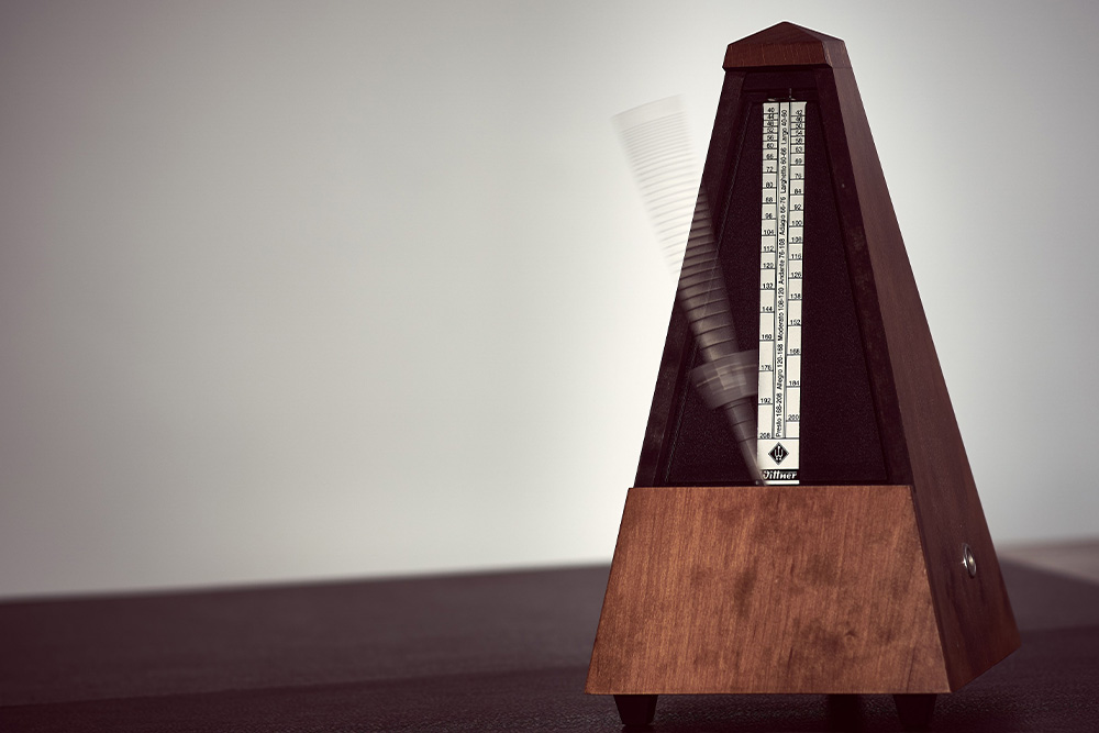 A metronome is in the middle of action to suggest that words have power in rhythm