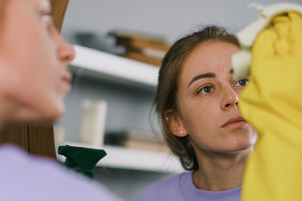 A woman looking into a clean mirror to suggest that good writing that is actively avoiding plagiarism allows the conscience to be clear