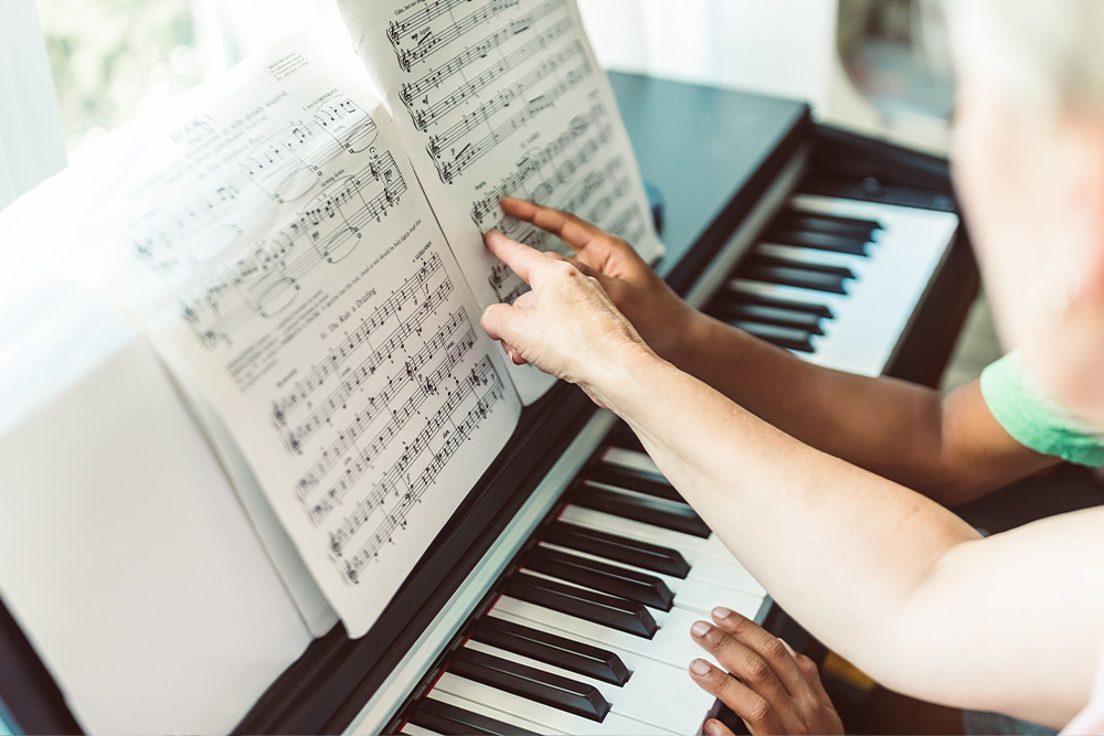 Two people point at a music score to suggest how to overcome common rhythm mistakes in what is rhythm