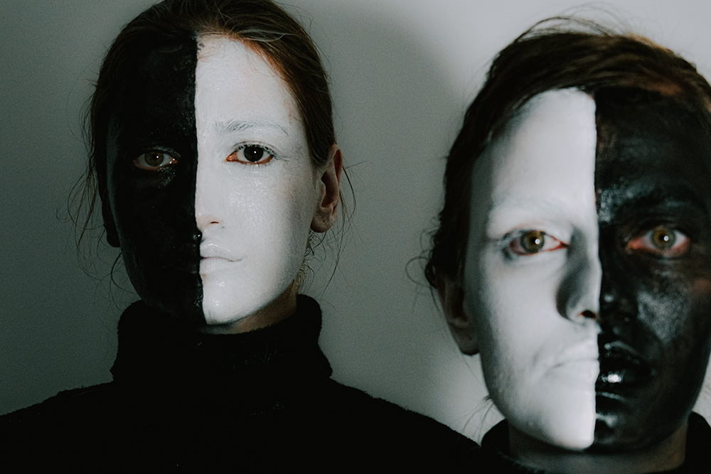 A duality is suggested in two characters placed next to one another with half painted faces to suggest that a character sheet should focus on the internal world of characters as well as external