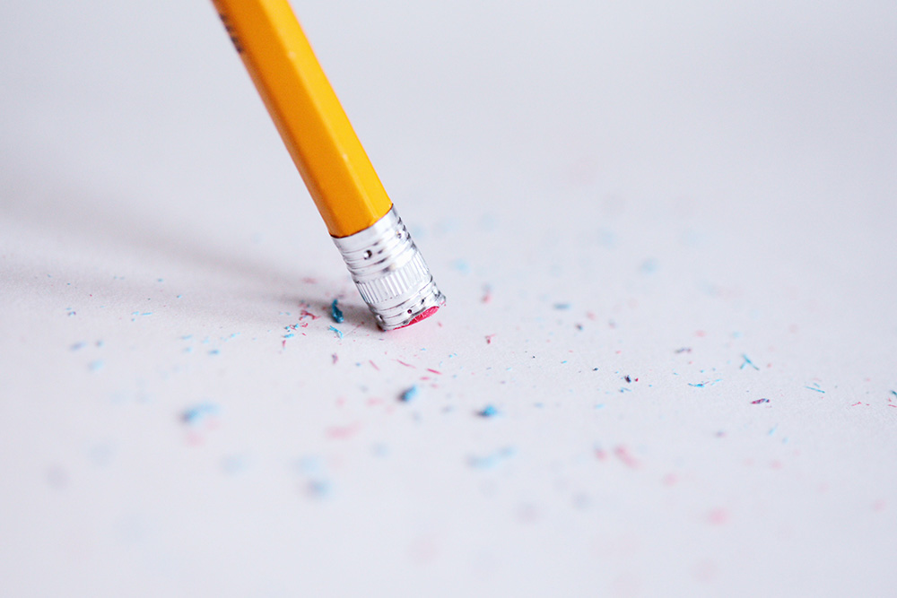 Eraser shavings adorn a paper to suggest the mistakes that one might make while writing a character sheet