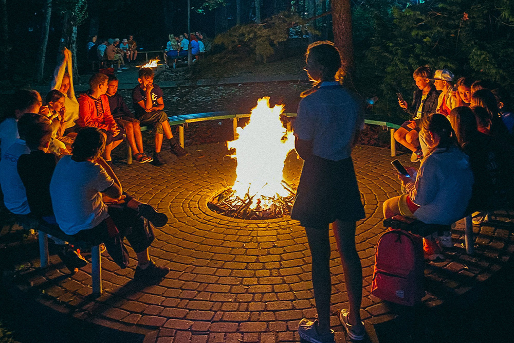A girl stands at the edge of a fire circle suggests that not knowing how to give feedback in a critique circle alienates someone from other writers