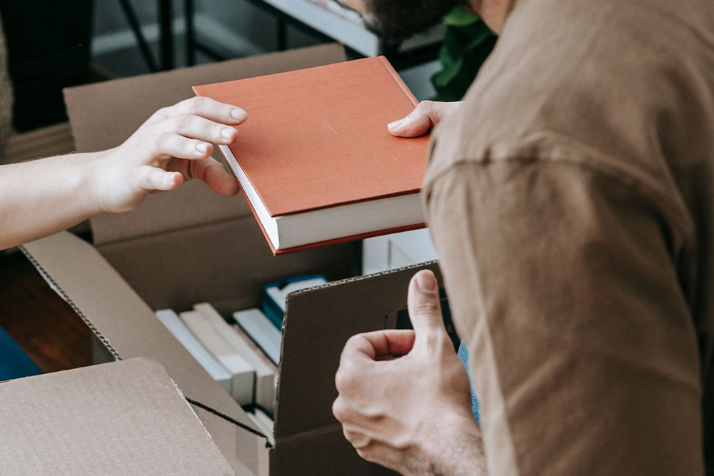 Books are unpacked in a warm cool lighting tone to suggest lightness in how to start a memoir