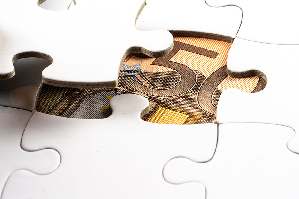 A puzzle with a banknote under a revealed puzzle piece suggests a hidden benefit to peer learning