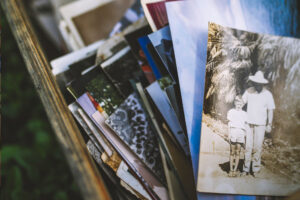 A picture of photographs in a wooden crate suggests examples of memoirs to help writers find their own stories