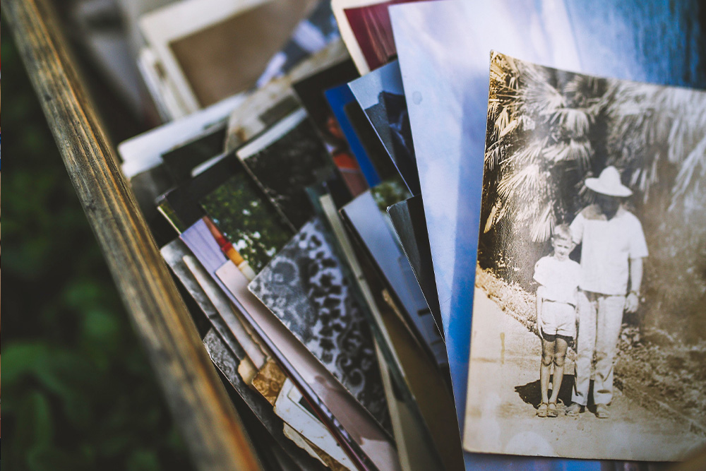 A picture of photographs in a wooden crate suggests examples of memoirs to help writers find their own stories