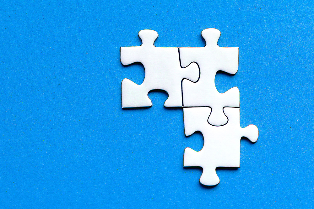 Three puzzle pieces fit together neatly on a blue background as a sense of smallness to suggest making the lines fit in a process of book editing