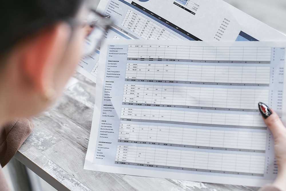 Someone with a spreadsheet out in front of them suggests an analytical and measured tactical approach to checking numbers in amazon marketing services