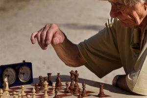 An elderly man at a chess game to suggest antagonist examples in relative position to the protagonist