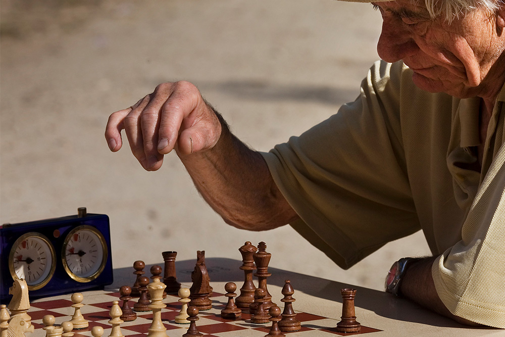 An elderly man at a chess game to suggest antagonist examples in relative position to the protagonist