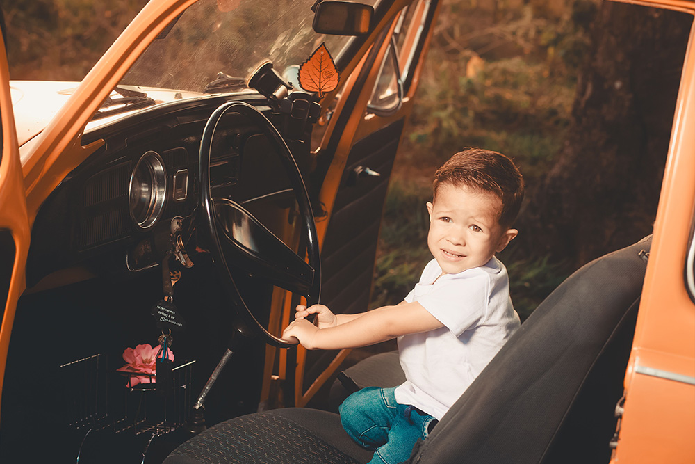 A kid in the front seat of a car about to drive to signify being safe 