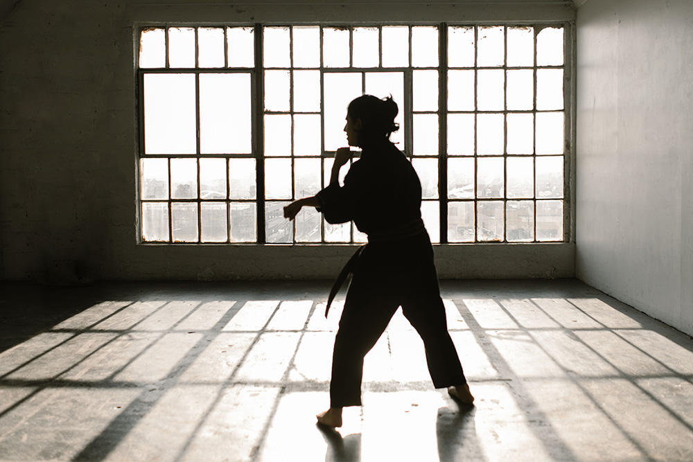 A woman in silhouette undertaking a martial art suggests some level of meditative quality or character development taking place
