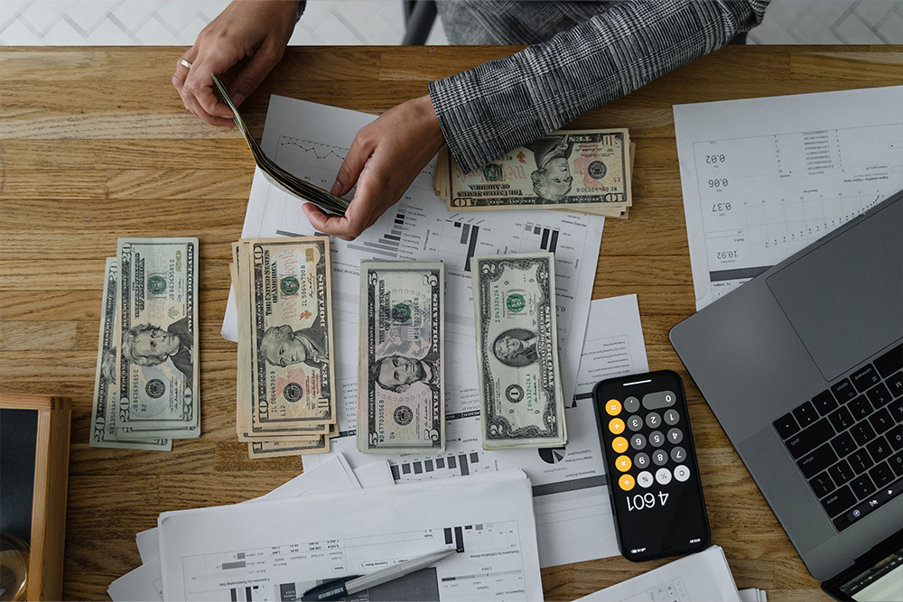 A picture of someone in a professional setting cleaning up their work desk and arranging expenses suggest that publishing is not always solely what tells how much do writers make