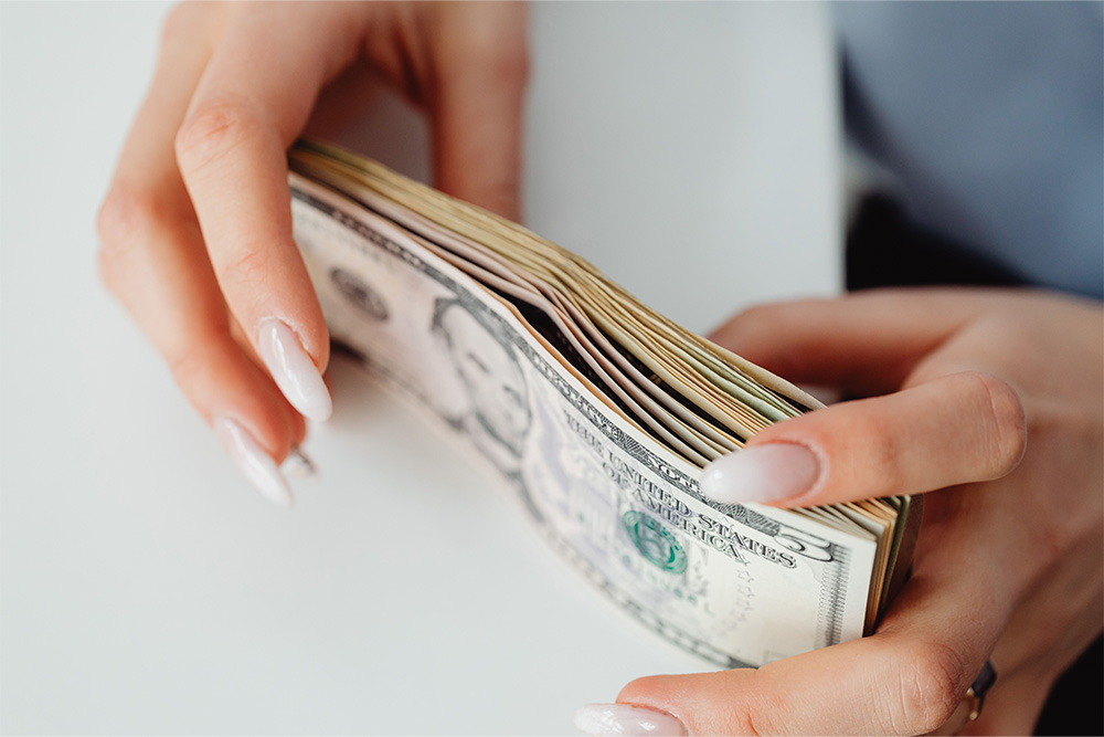 A stack of money in a pair of hands suggests the question how much do writers make