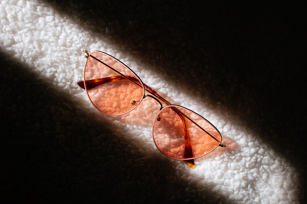 a pair of rose colored glasses on carpet suggests that tone shapes how readers interpret events and how it differs in mood vs. tone
